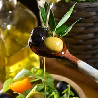 Cuchara con aceitunas y aceite