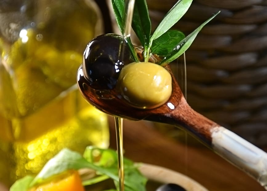 Cuchara con aceitunas y aceite